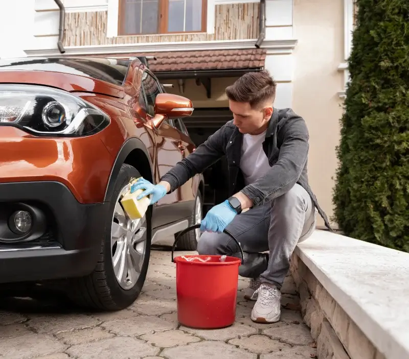 Lavage auto à domicile Fontenay-le-Marmion : professionnel intervenant sur un véhicule